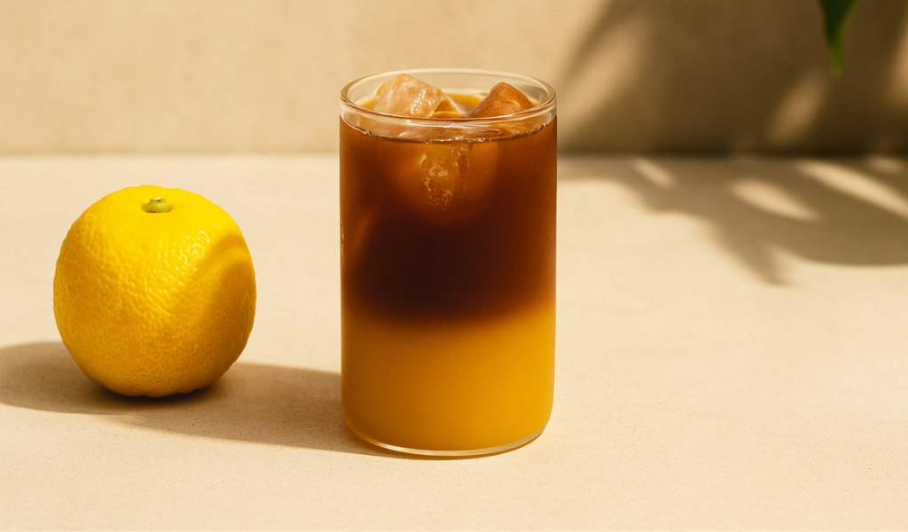 Yuzu Espresso Tonic Glas mit Eiswürfeln und einer Yuzu Frucht