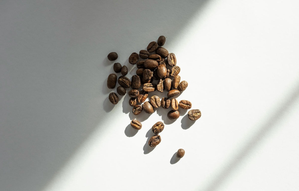 Ganze Kaffeebohnen auf weißem Untergrund