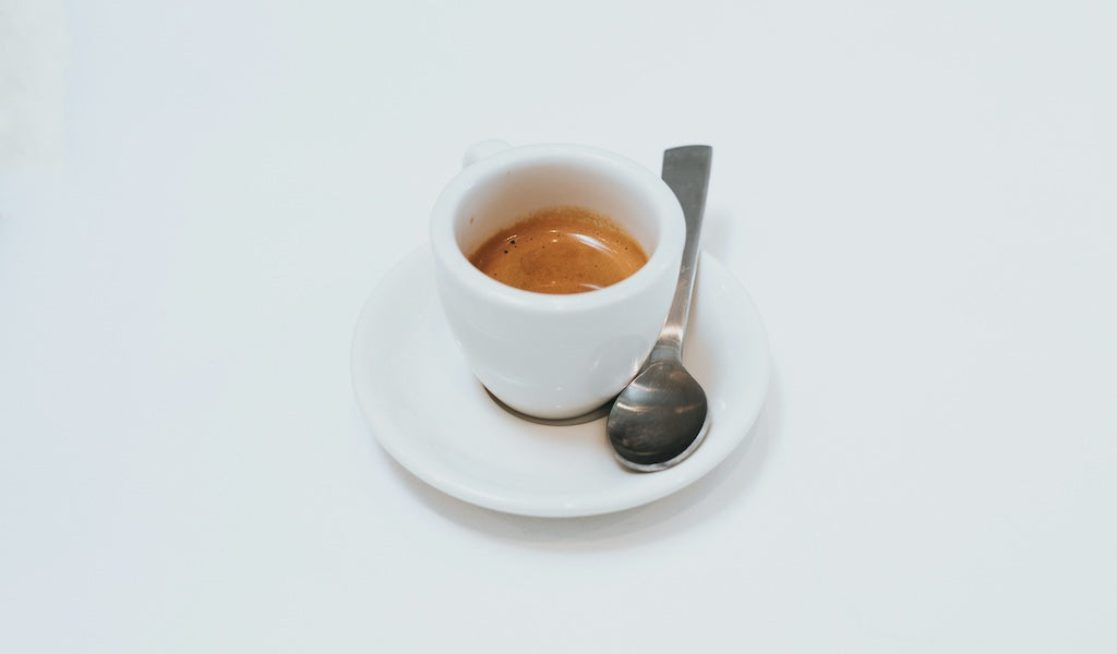 Espresso in weißer Tasse, weißer Hintergrund
