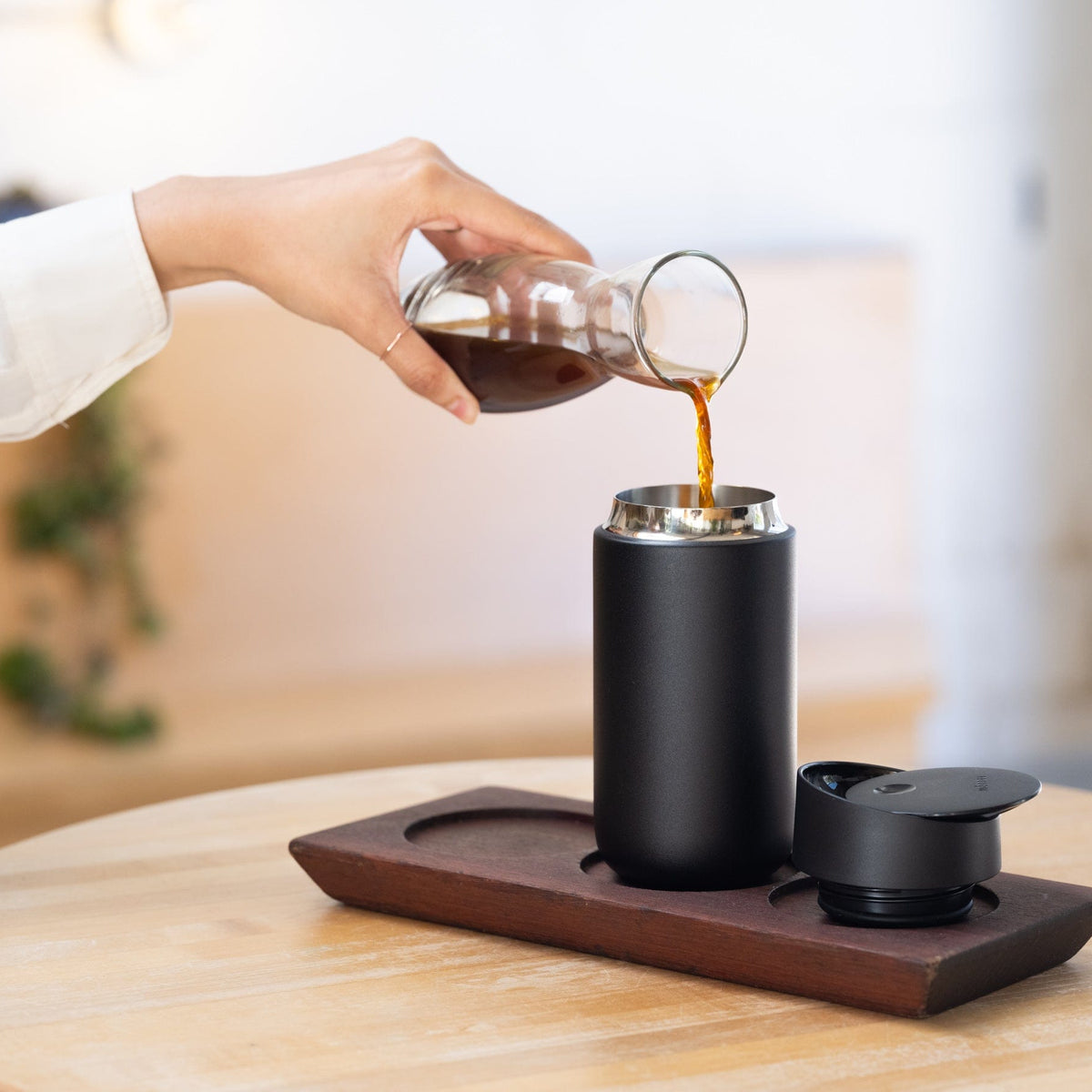 Fellow Carter Slide Move Thermobecher in Schwarz wird mit Kaffee befüllt - nuruCoffee