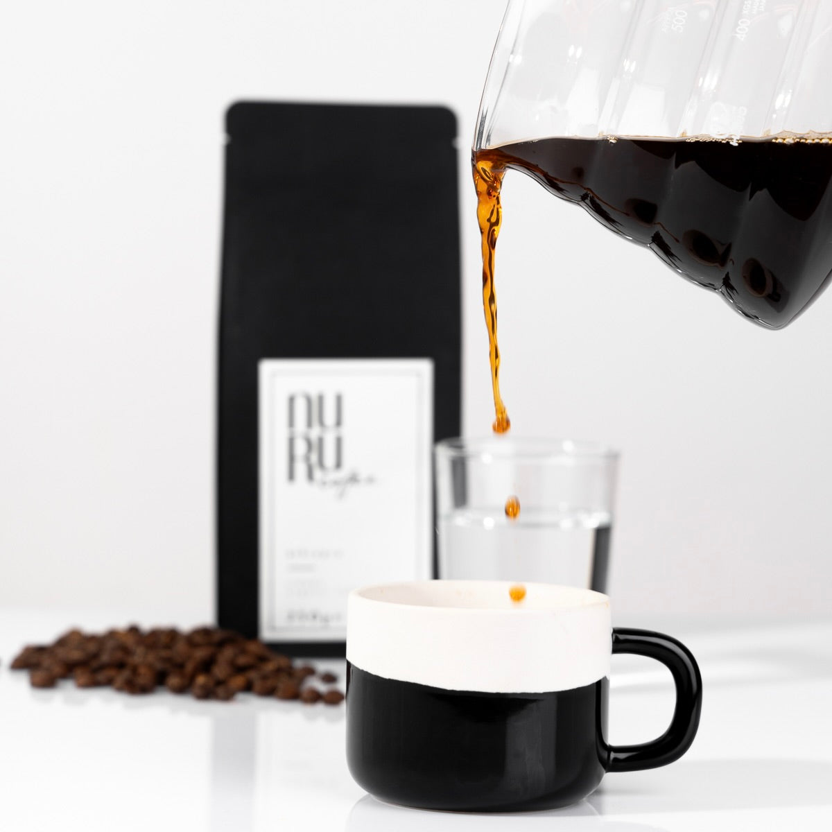 Von den Gründerinnen Sali und Sara Nuru I Kaffeetasse mit eingeschenktem Kaffee und Verpackung von nuruCoffee - nachhaltiger, fair produzierter Bio-Kaffee mit social impact