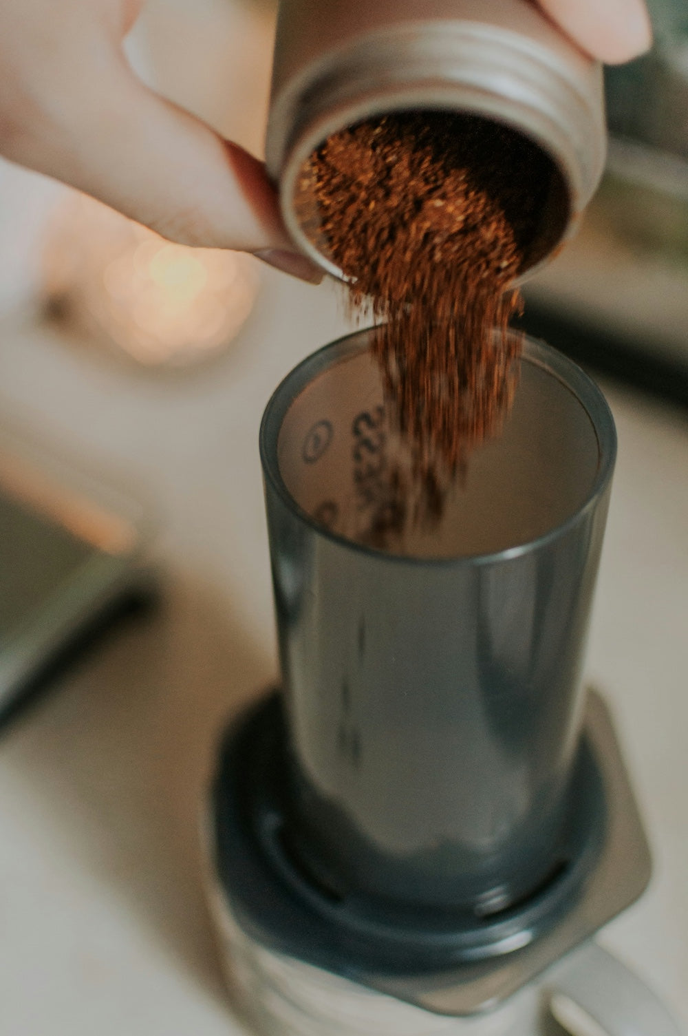 Kaffeemehl wird aus Mühle in Aeropress gefüllt - nuruCoffee