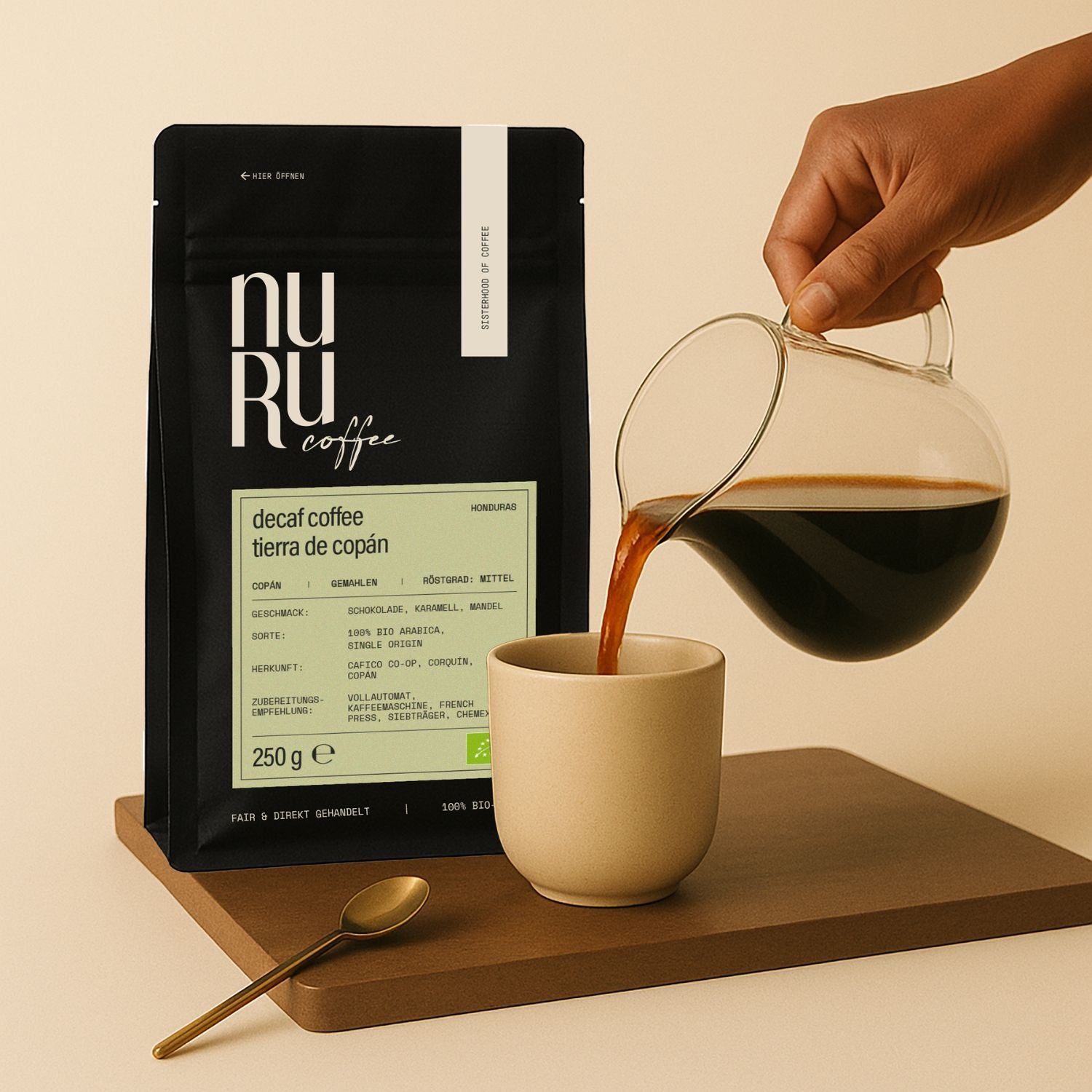 Verpackung mit DECAF Coffee Tierra de Copán auf Holzbrett mit Keramiktasse, in die schwarzer Kaffee gegossen wird