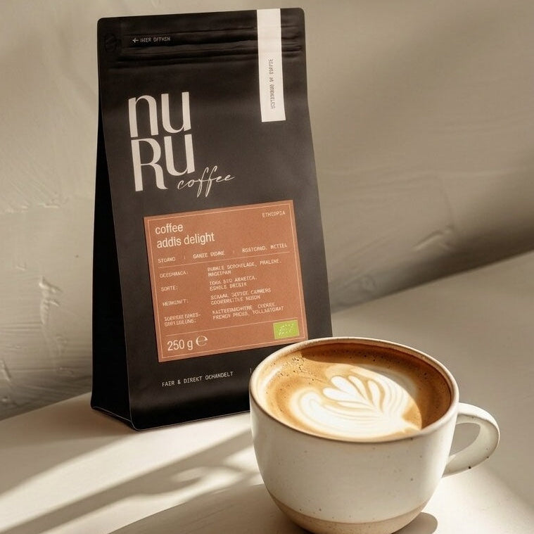 Bio Kaffee Addis Delight im zarten Sonnenlicht, Tasse mit Latte Art