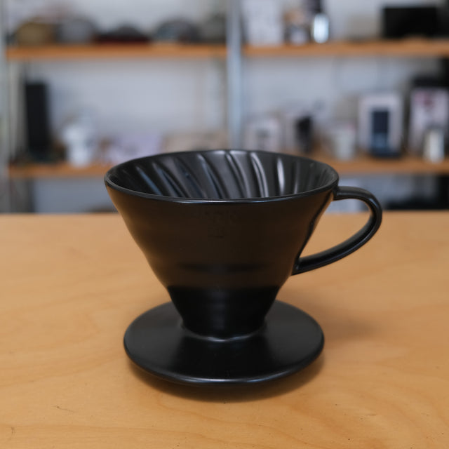 Hario V60 Dripper Porzellan Schwarz auf Küchentheke, Hintergrund verschwommen - nuruCoffee