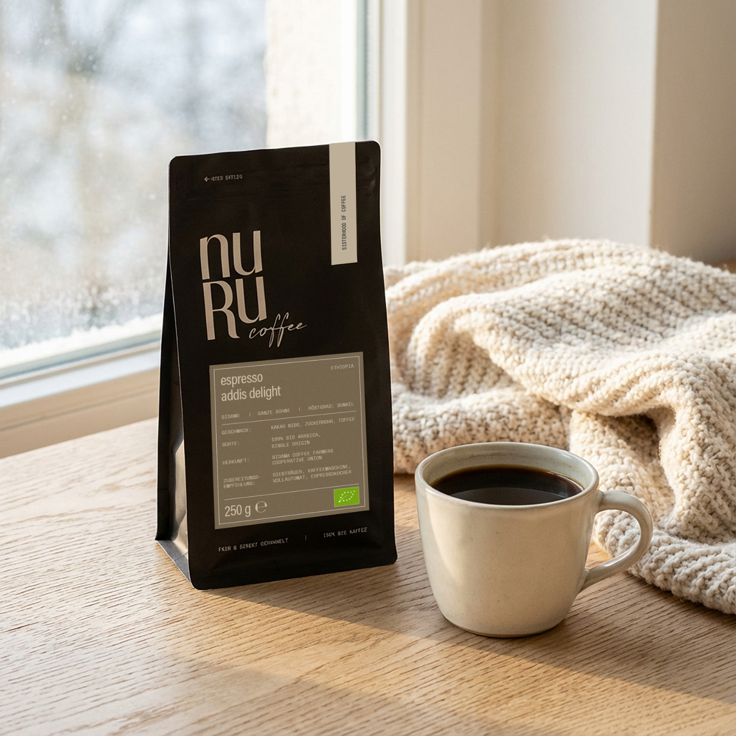 Bio Espresso Verpackung mit Tasse schwarzem Kaffee und kuscheliger Decke auf Fensterbank