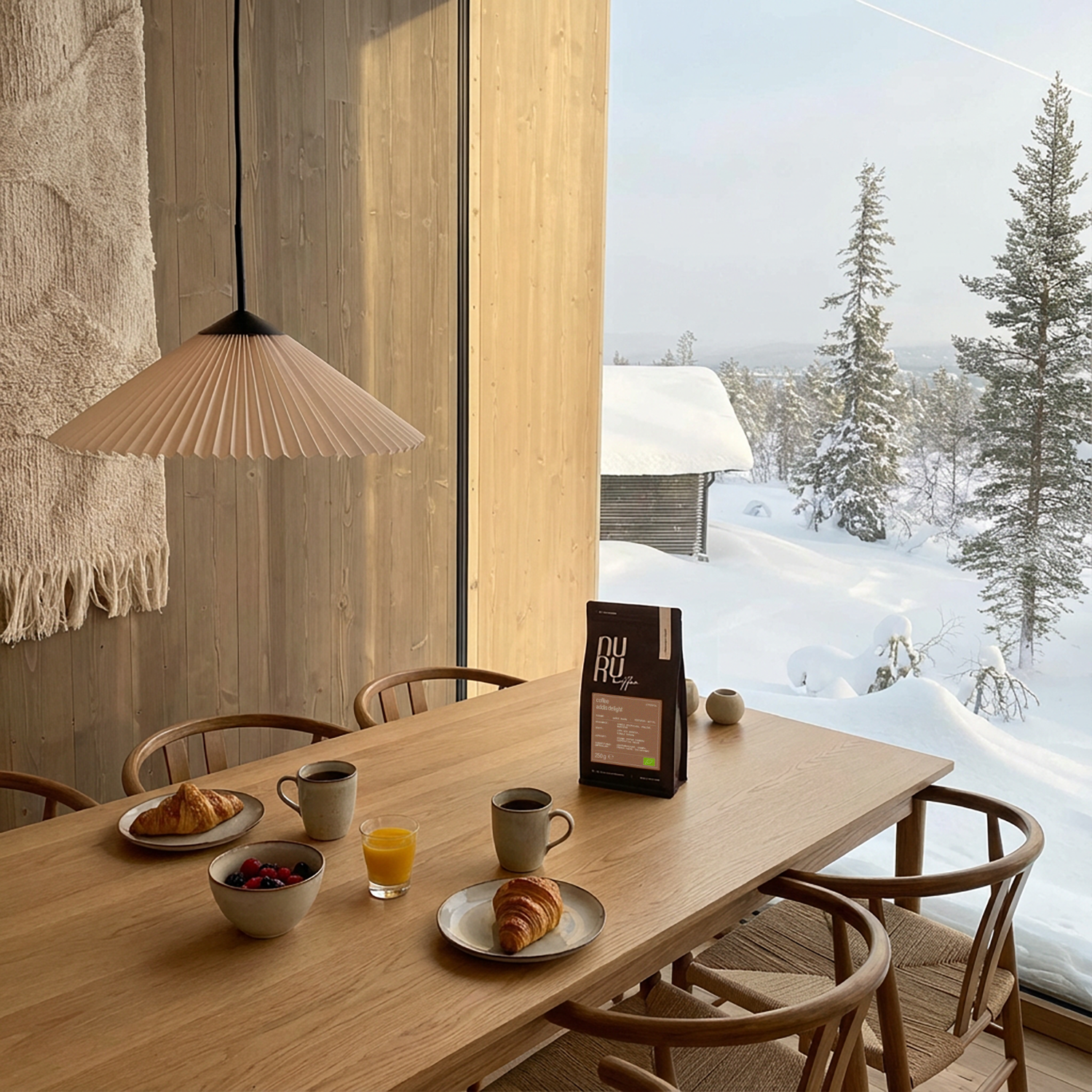 Bio Kaffee auf gedecktem Frühstückstisch vor großem Fenster mit winterlicher Landschaft